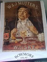 Tea towel featuring vintage Bowmore Islay Whisky advertisement with man, bottle, and whisky glass, laid flat to show design