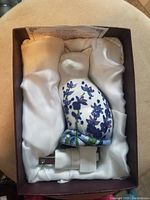 Vintage cat-shaped ceramic nightlight with painted floral pattern inside original satin-lined box