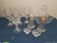 Photo showing six vintage cut crystal goblets, crystal basket with handle, pair of salt and pepper shakers, and two small candle holders.