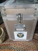 Front view of metal travel storage box showing latch, metal reinforcements, handles, and Varel Rock Bits Canada sticker.