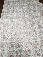 Photo showing full spread of cotton table cloth with intricate pink flower and green vine pattern