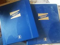 Two blue Commemorative Stamp Club albums, glossy with some wear spots.