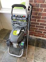 Front view showing the unit, control panel labeling PSI and GPM, coiled hose.