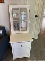 Four-section white wood frame with glass windows, showing scratches and marks.