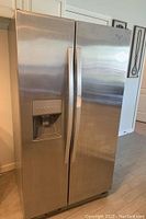 Front view of stainless steel Whirlpool side-by-side refrigerator with water and ice dispenser