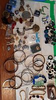 Overview of bracelets, earrings, pins spread on surface