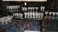 Various etched crystal glasses arranged on couch and coffee tables