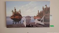 Front view of canvas print showing two white Muskoka chairs on a dock overlooking a lake with trees and islands.