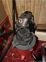 Photo showing Craftsman 45-liter shop vac with 4.0 HP motor and black, red tank. Hose and wand seen to side.