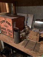 Photo of the vintage Crown Derby tea box alongside the metal grater and various items on a wooden surface