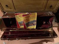 Full view of trombone inside hard case with two music books on top