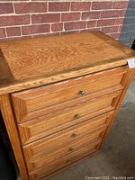 Full front and top view of tall oak chest of drawers with 5 drawers