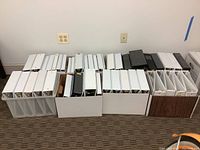 Wide shot of boxes with white and black binders showing various sizes 1,2,4,6 inch