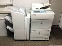 Full view of Canon imageRUNNER 5055 multifunction printer unit with attached paper sorter finisher unit on left side and automatic document feeder on top right.