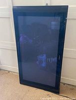 Photo of the entire front face of the flat plasma TV device, showing the screen, bezel, and side speakers.