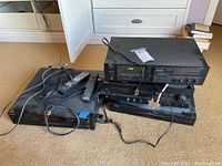 Photo showing stacked Yamaha cassette deck, Yamaha AV receiver, DVD player, with cables and remotes on floor.