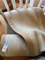 Rolled sisal rug showing beige fabric borders and textured weave.