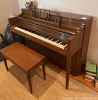Full view of Wm Knabe & Company upright piano with matching storage bench in front, showing keyboard, music stand, and wood finish.