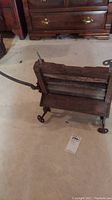 Front view of the antique clothes wringer showing wooden frame and metal rollers with rustic finish.