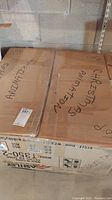 Two large brown shipping boxes labeled "Christmas Animation" and "Animatronics" stacked in basement.
