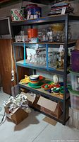 Metal shelving unit holding colorful kitchenware and glass jars, showing scrapes and use wear.