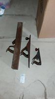 Three vintage wood planers arranged on basement floor with visible wear and rust.