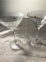 Two cocktail glasses upright on fabric surface, clear glass with drinkruby.com logo visible on bowls.
