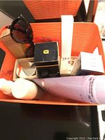 Image of boxed cosmetics including tubes, jars, and a pair of sunglasses.