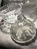 Crystal bowl with lid resting beside it, clear with scalloped pattern, stained needing cleaning