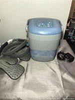 Front and top view of the Donjoy Iceman Classic medical ice machine with two cooling pads and AC power adapter shown