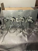 Photo of 5 clear Macy's wine glasses of different sizes in front of a Macy's branded box.