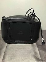 Front view of Sony portable digital tuner showing closed CD compartment, antenna, power cord, and control panel.