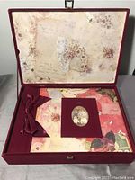 Scrapbook album inside decorative box showing vintage style cover with photo and ribbon bow
