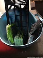 Multiple vegetable slicers and a protective glove in a blue bowl.