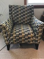 Front view of the high back armchair with upholstered circle pattern fabric showing seat, arms, and legs