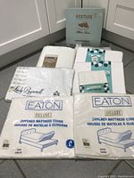 Photo showing six vintage bedding items in original packaging, including pillowcases and mattress covers.