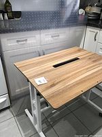 Wide view showing the workstation desk with wood finish surfaces and clear plastic floor mat behind it, partially rolled or adjusted.