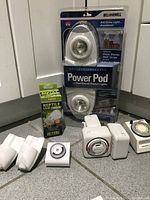 Overall lot with Power Pod packaging, timers and reptile UVB bulb shown on floor.