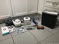 Photo showing full view of the lot including paper shredder, teapot, glass, flashlight, and other small items