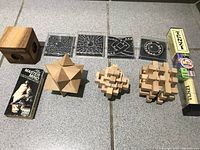 Full view of all items including wooden puzzles, metal maze puzzles, Mini Mastermind game and wooden boxes.