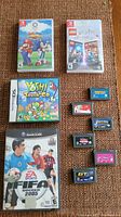 Photo shows all the game items included in the lot arranged on carpet: 2 Nintendo Switch games, 1 Nintendo DS game, 1 GameCube game, and 6 Gameboy Advance cartridges.