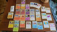 Table with arranged stack and spread of Pokemon GO trading cards including reverse holographic, energy, markers, and code cards.