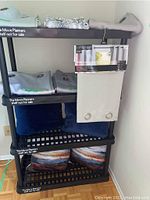 Shelving unit with folded curtain panels and pillows arranged on different shelves