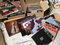 Two cardboard boxes filled with assorted vinyl records viewed from above