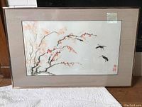 Front view of framed watercolor painting with two cranes and flowering branch.