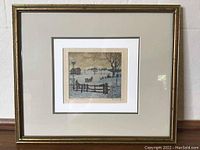 Full view of the framed aquatint artwork showing gold-tone frame, white matting, and centered print depicting winter rural scene.