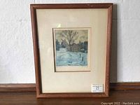 Framed aquatint print showing the full piece with wooden frame and off-white matting on wall and floor background.