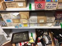Shelf with multiple labeled boxes containing different years and brands of baseball and football cards.