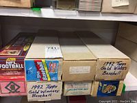 Photo showing multiple labeled boxes of trading card sets including 1992 Topps Gold Winners Baseball and 1991 Topps Baseball.