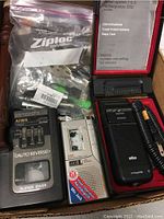 Photo showing Braun rechargeable system 3510 foil shaver in original box with cord and attachments, AIWA T220A radio cassette player, Sony 24 hour recorder, and other small recorders and accessories.